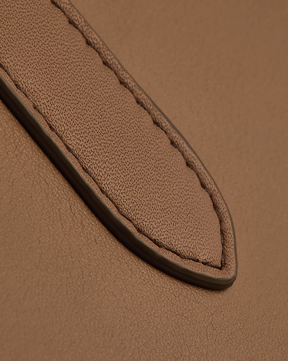 Close-up of clay mini tote leather showing stitched handle detail