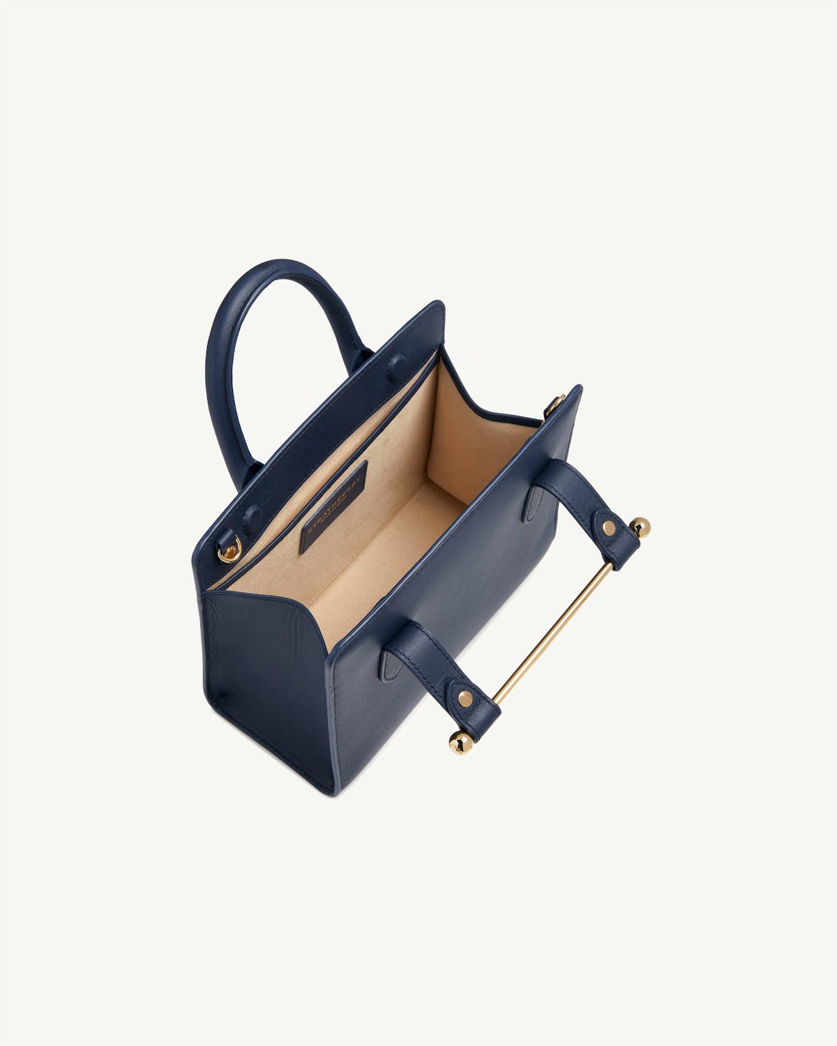 Strathberry marine blue mini tote with open top and beige interior