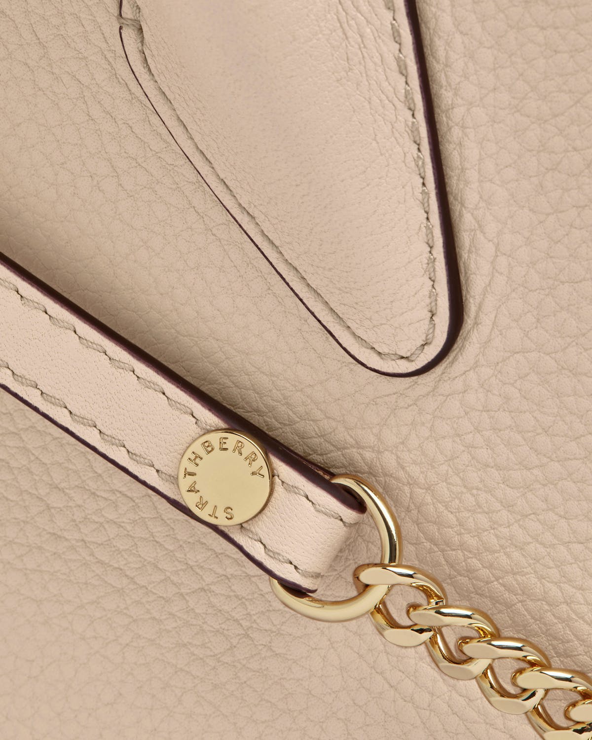 Strathberry oat mini tote leather close-up of strap, gold chain and pebble grain