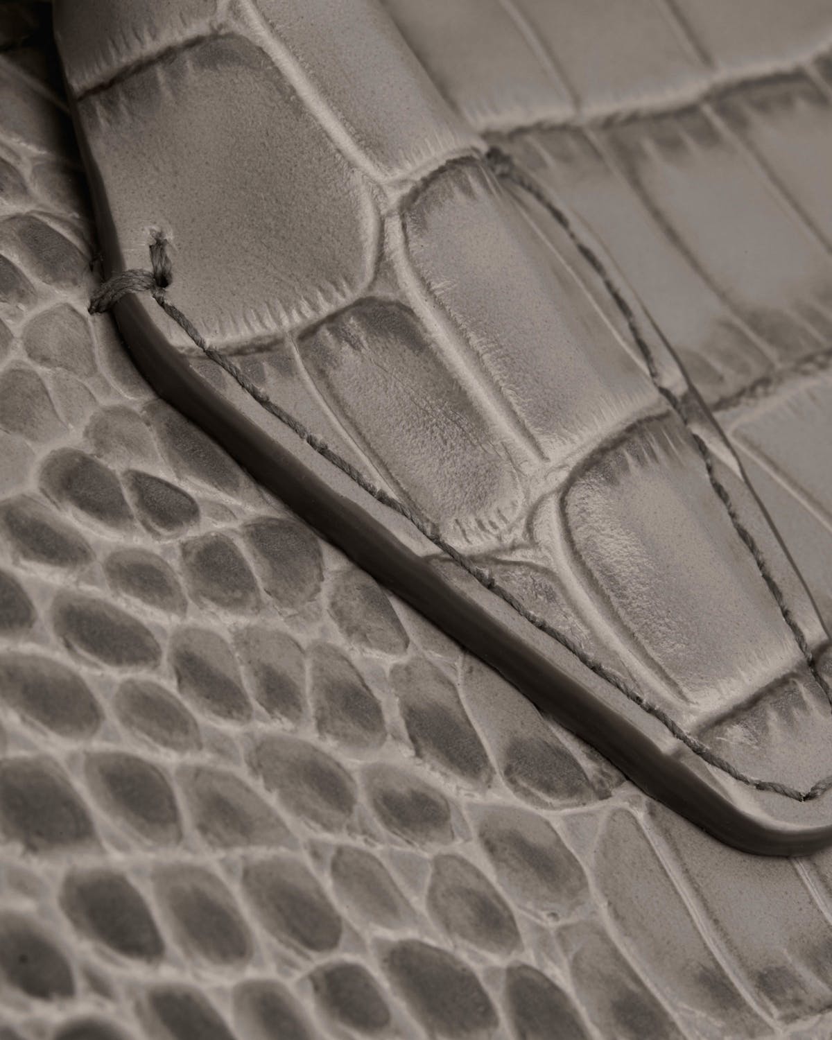 Close-up of soft croc mini tote showing flap edge and stitched leather texture