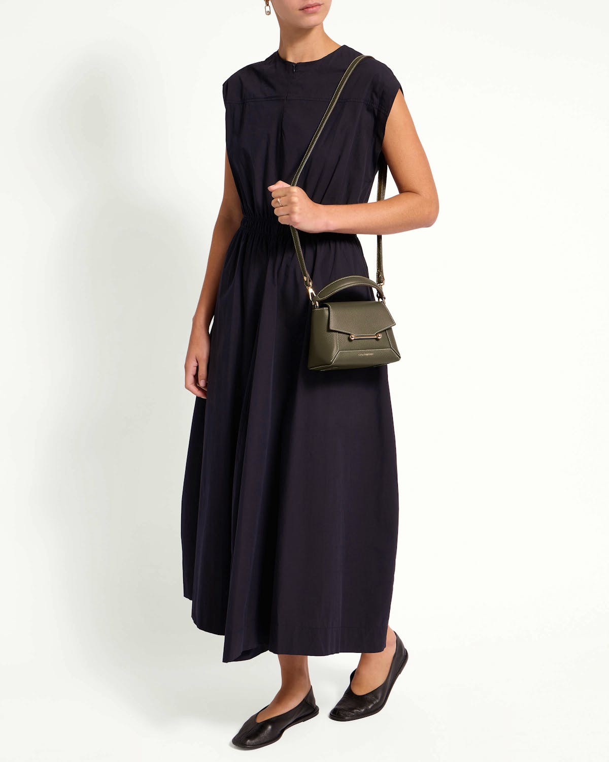 Model wearing khaki Mosaic Nano crossbody bag with top handle and gold hardware.