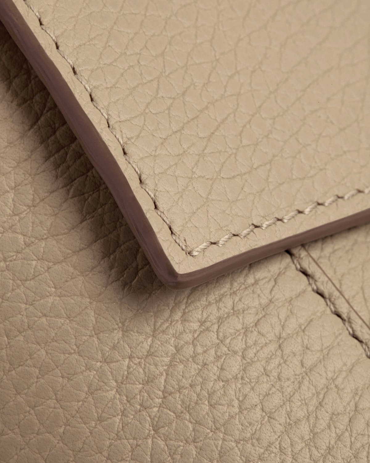 Close-up of sand pebbled leather flap and stitching on Mosaic Nano bag