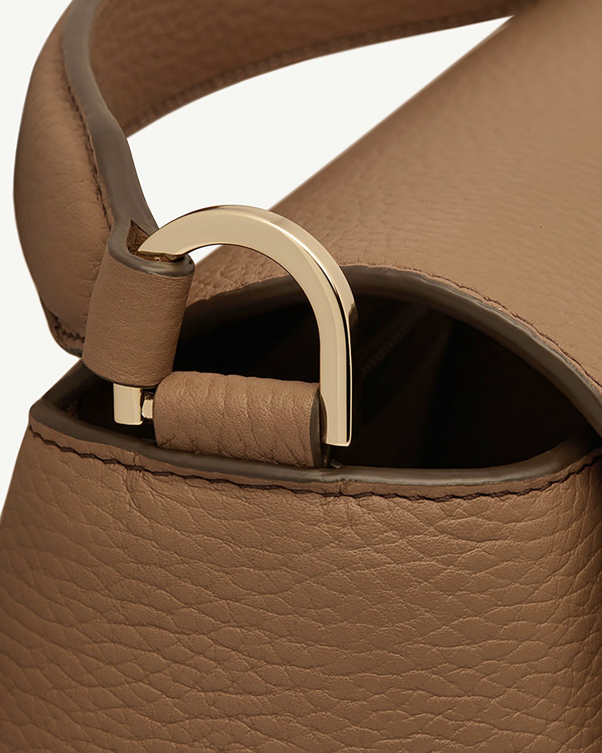 Close-up of clay mosaic bag handle and gold arch hardware