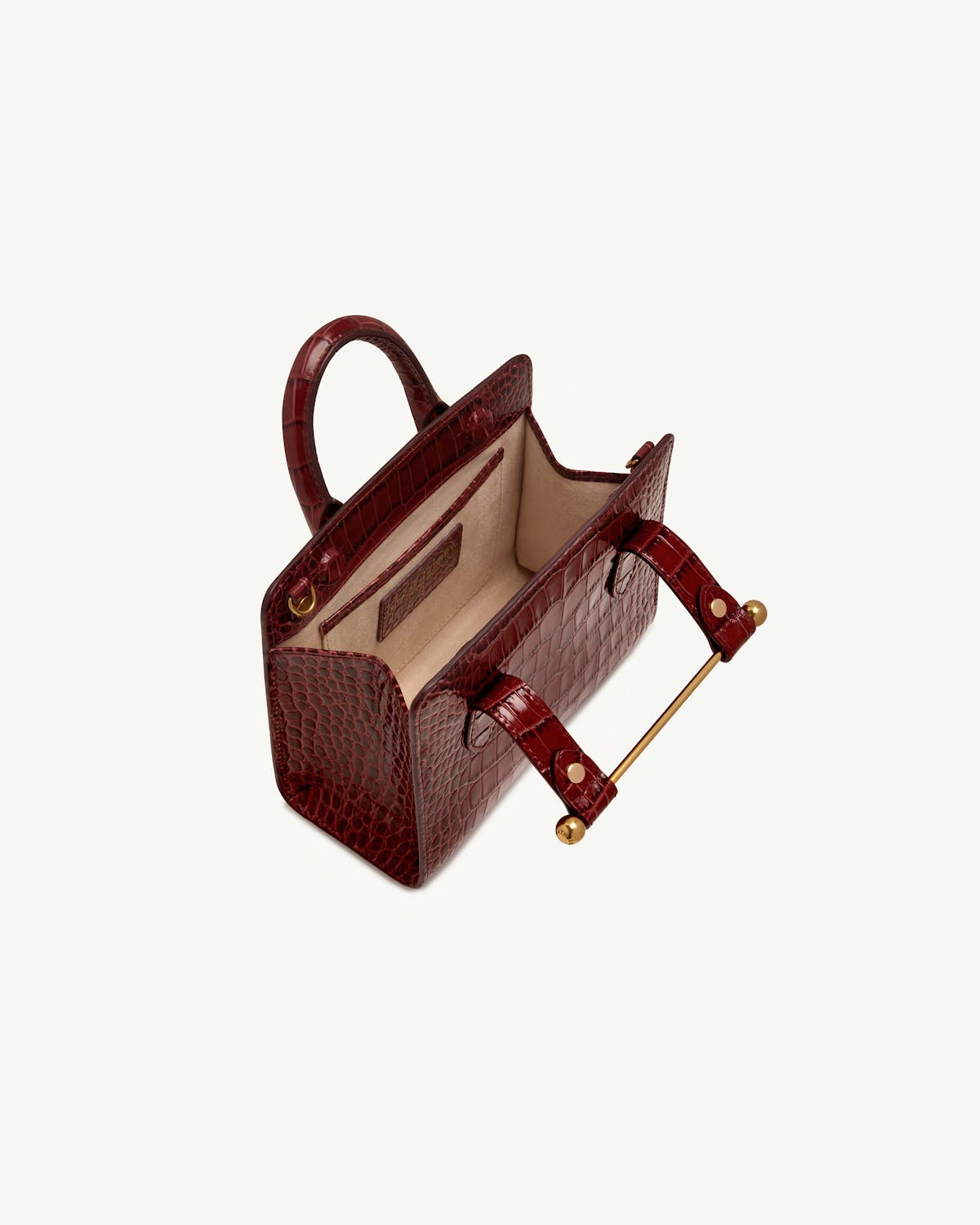 Croc nano tote open, showing beige interior and gold bar handle