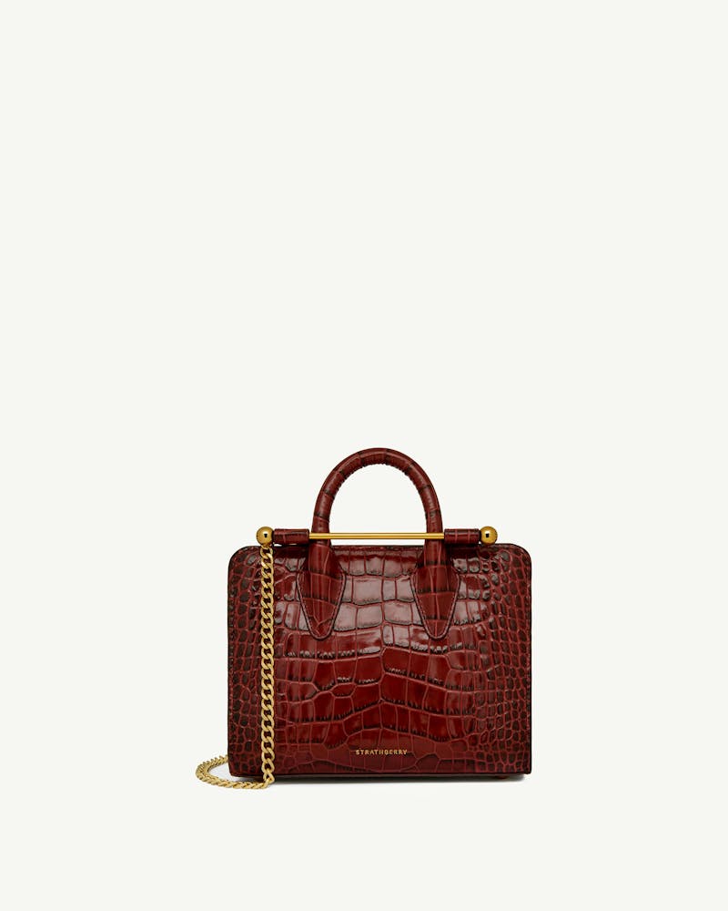 Strathberry Nano Tote in croc leather with top handles and gold chain.