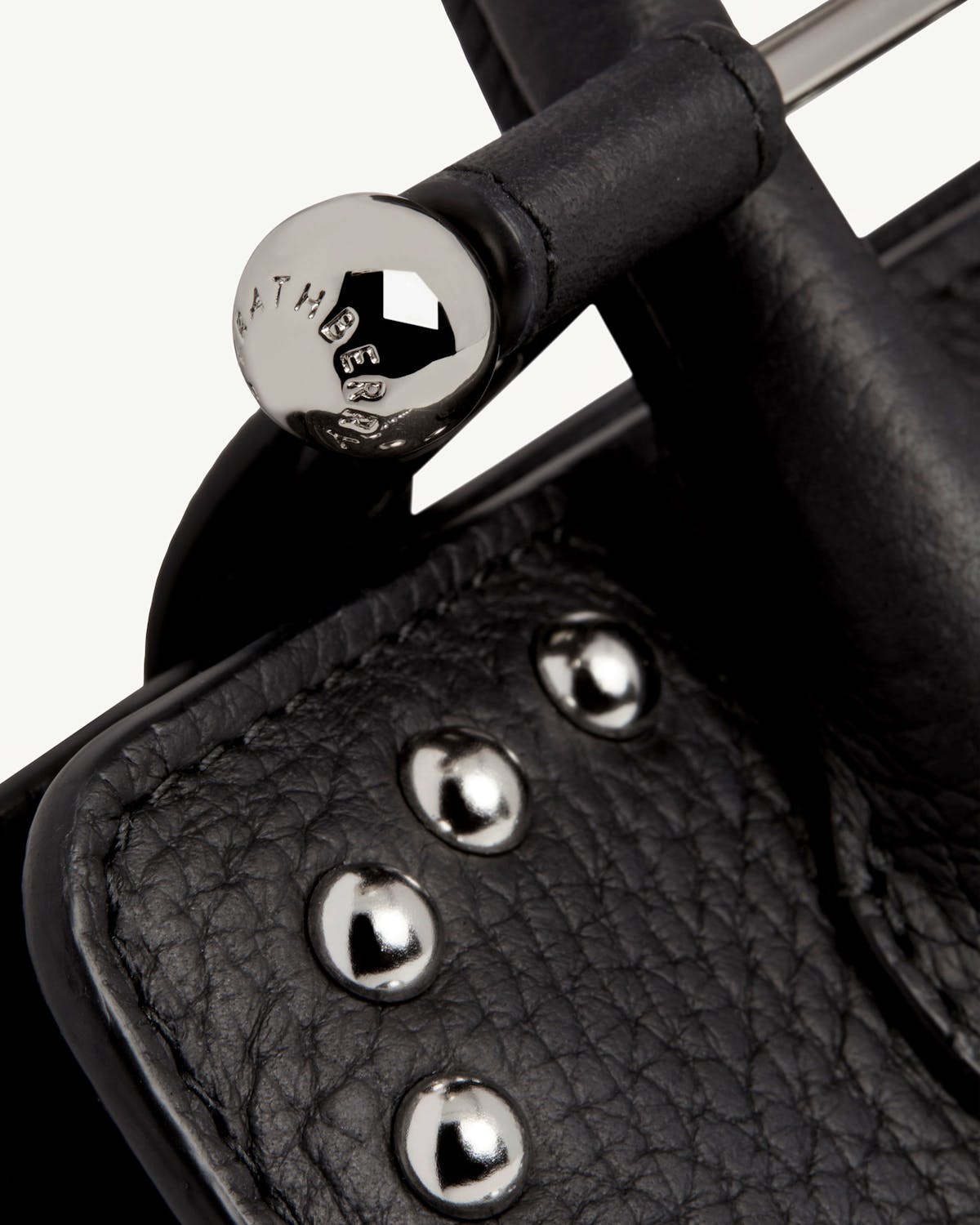 Close-up of Strathberry Nano Tote black studded leather handle and studs