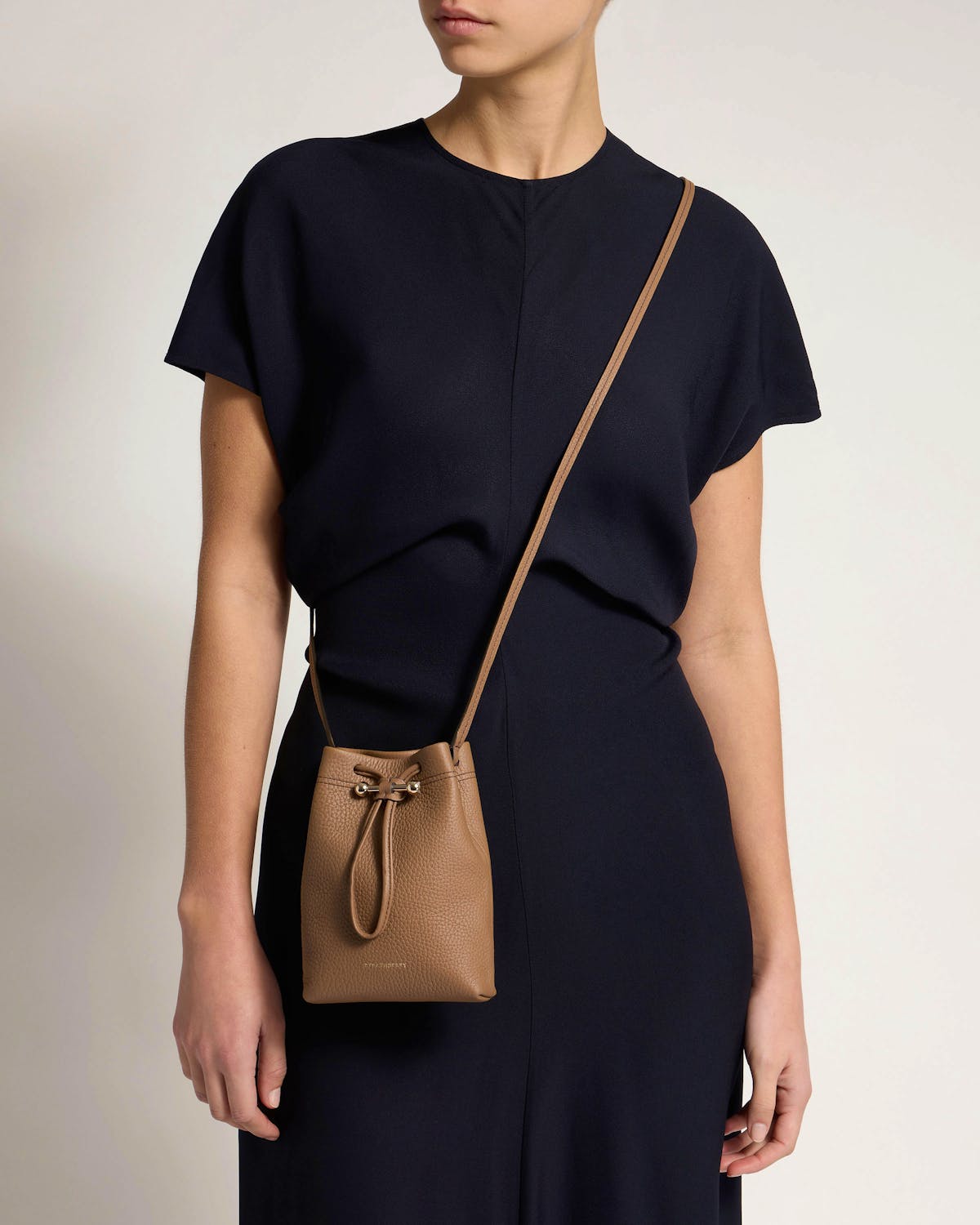 Model wearing clay Osette midi pouch crossbody at hip