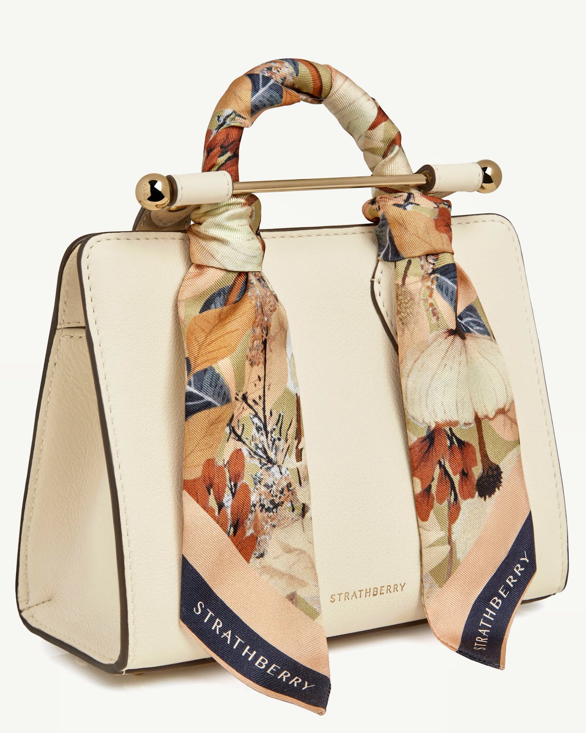 Silk skinny scarf in autumn floral print tied to cream Strathberry handbag handle.