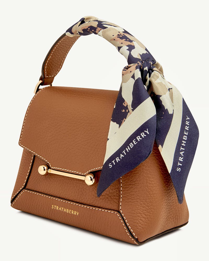 Navy and sand abstract floral silk skinny scarf tied to Strathberry tan leather bag