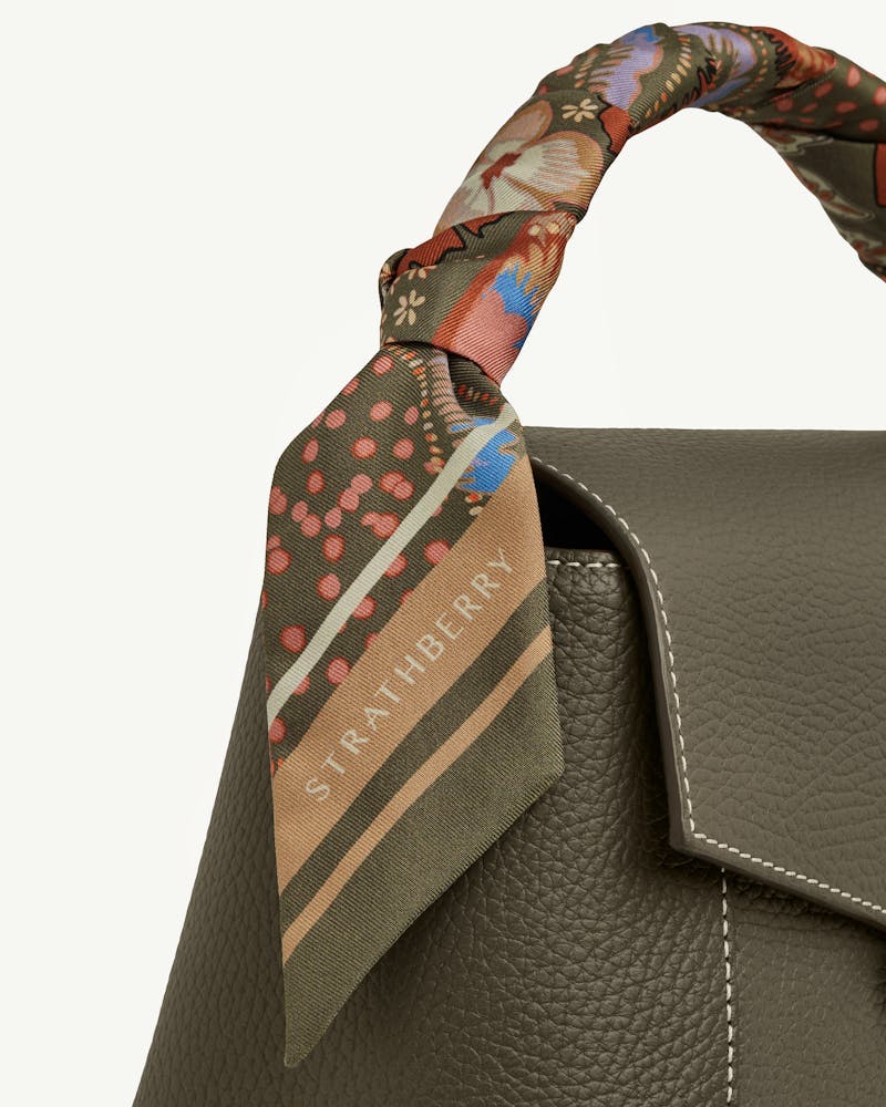 Strathberry silk skinny scarf embroidery print khaki caramel tied to bag handle