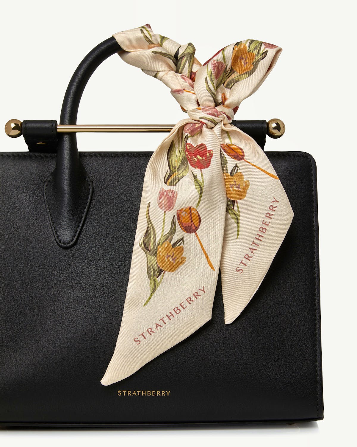 Vanilla tulip print silk skinny scarf tied to black Strathberry bag handle.