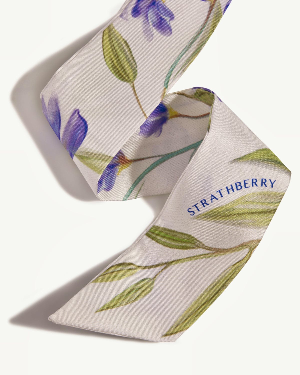 Vanilla silk skinny scarf with blue watercolour floral print and Strathberry logo.
