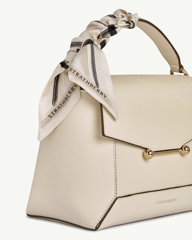 Sand and vanilla tartan silk skinny scarf tied to Strathberry cream-coloured leather bag.