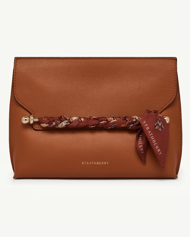 Tan leather Strathberry bag with oxblood tulip print silk skinny scarf braided across front bar