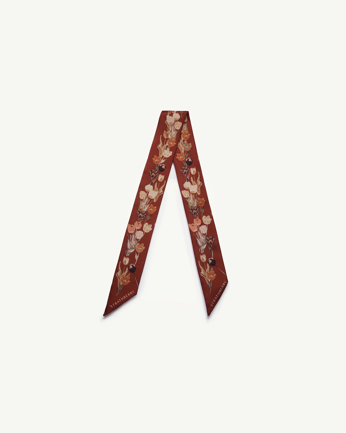 Oxblood silk skinny scarf with tulip print and Strathberry logo, folded into a V shape.