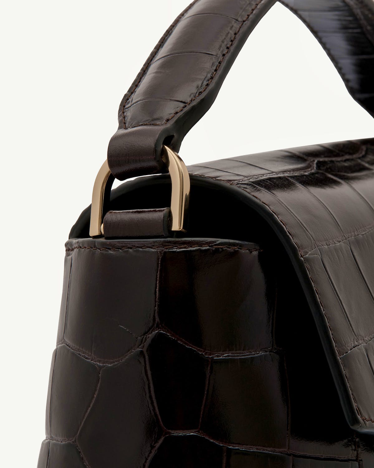 Dark croc-embossed leather mosaic bag handle with gold-tone metal hardware and stitching.