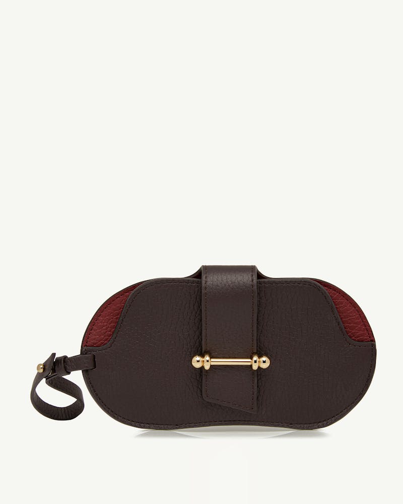 Espresso and oxblood leather sunglasses case with gold bar and wrist strap loop.
