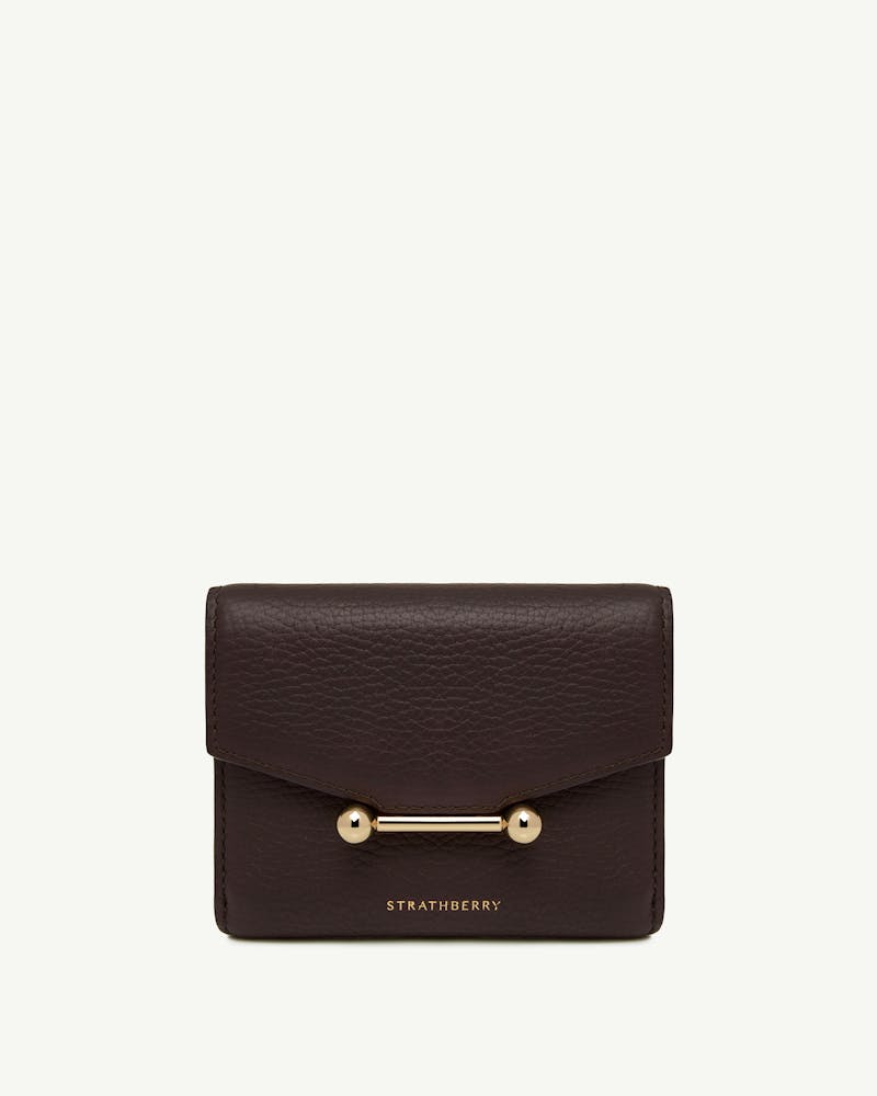 Espresso leather trifold wallet with gold bar hardware and Strathberry wordmark.