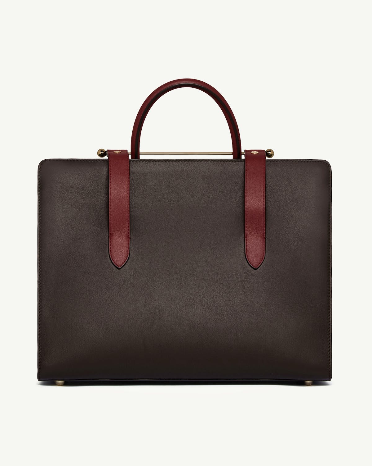 Espresso leather tote with oxblood handles and straps on a white background.