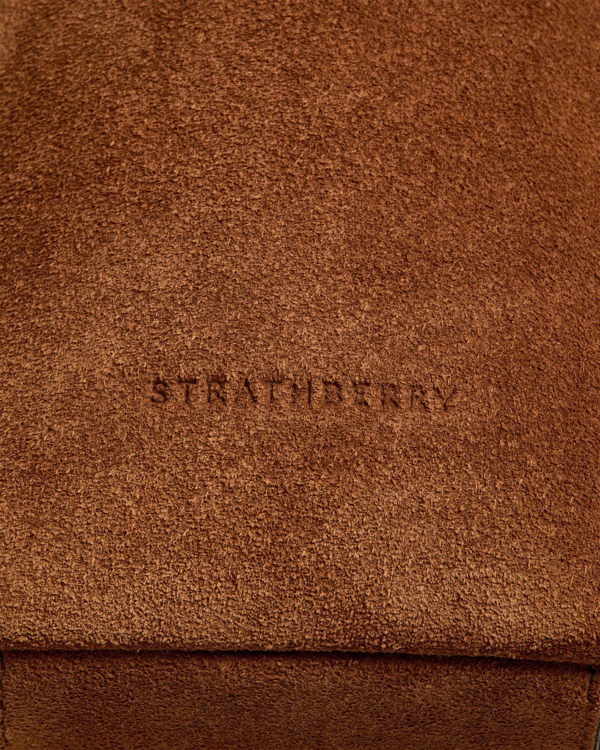 Tan suede Kite Hobo close-up showing Strathberry embossing and suede texture.