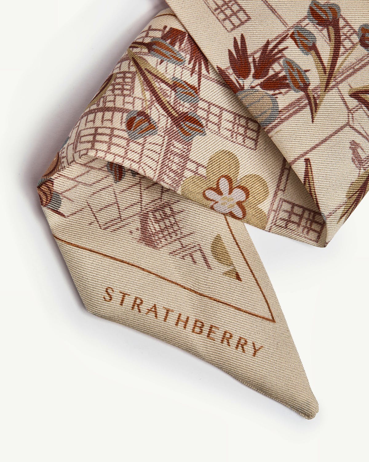 Folded silk skinny scarf with Strathberry Townhouse print, logo visible.