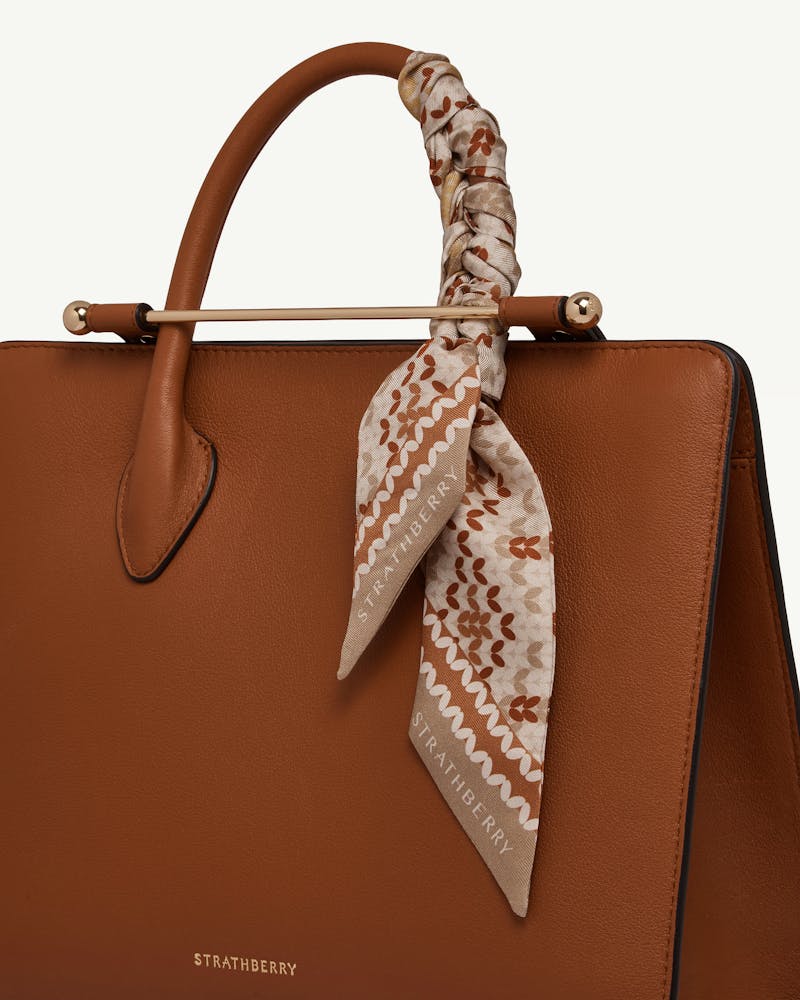 Brûlée Fair Isle silk skinny scarf tied to tan Strathberry handbag handle