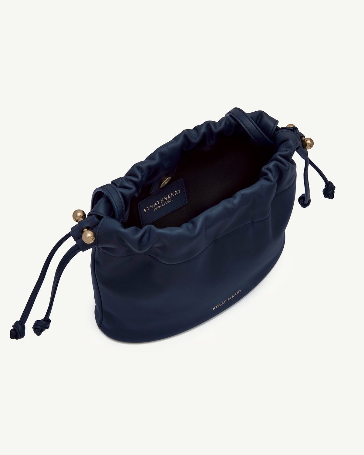 Marine blue drawstring leather bag with gold hardware and Strathberry logo.