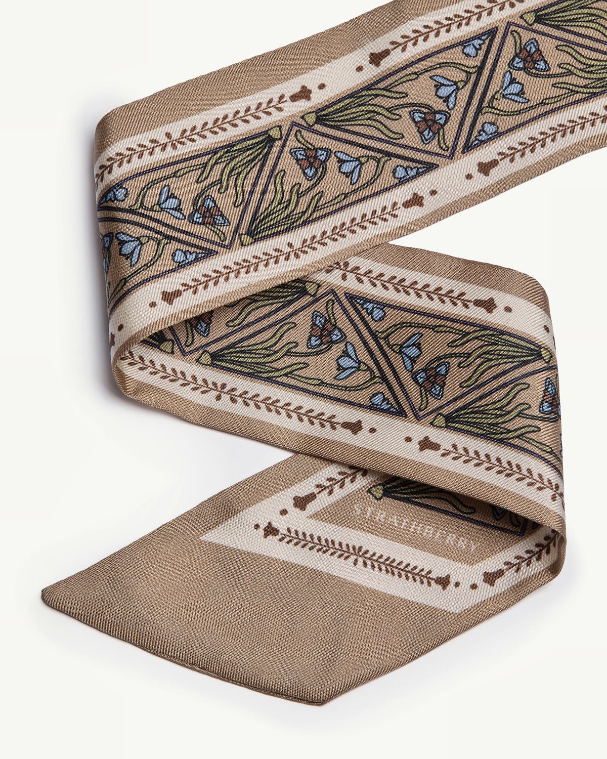 Strathberry silk skinny scarf in geometric caramel pattern, folded on white background.