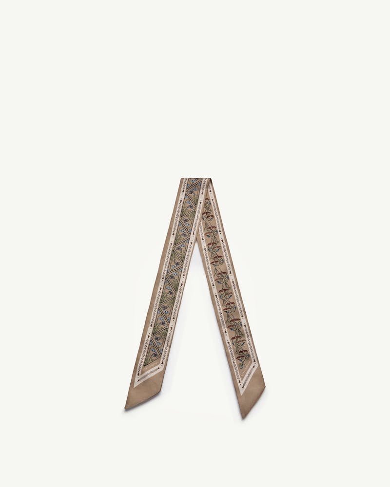 Silk skinny scarf in geometric caramel pattern folded into a V shape.