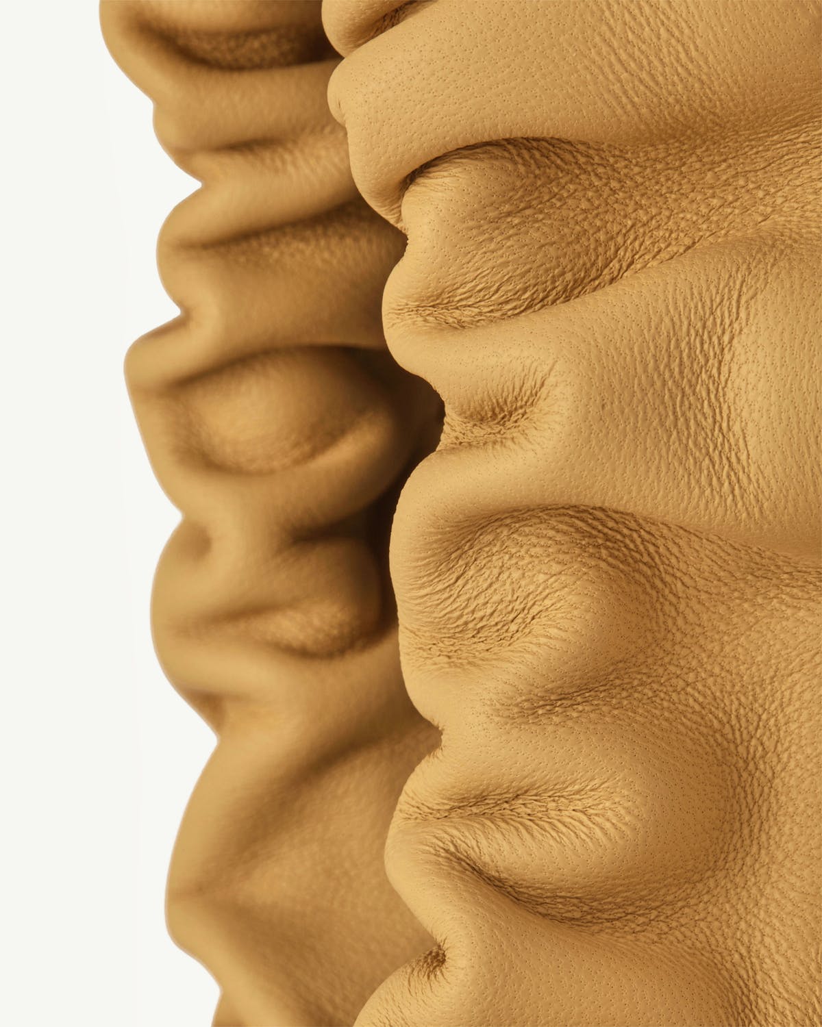 Ruffled brûlée tan pebbled leather panel of a drawstring bag, textured folds visible.