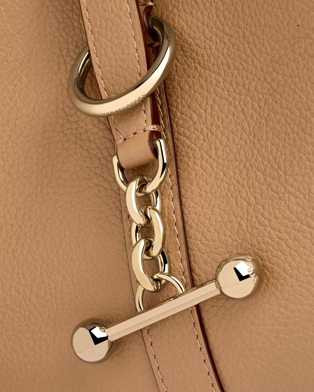 Detail of a Strathberry Kite Hobo in caramel leather with gold chain and T-bar.
