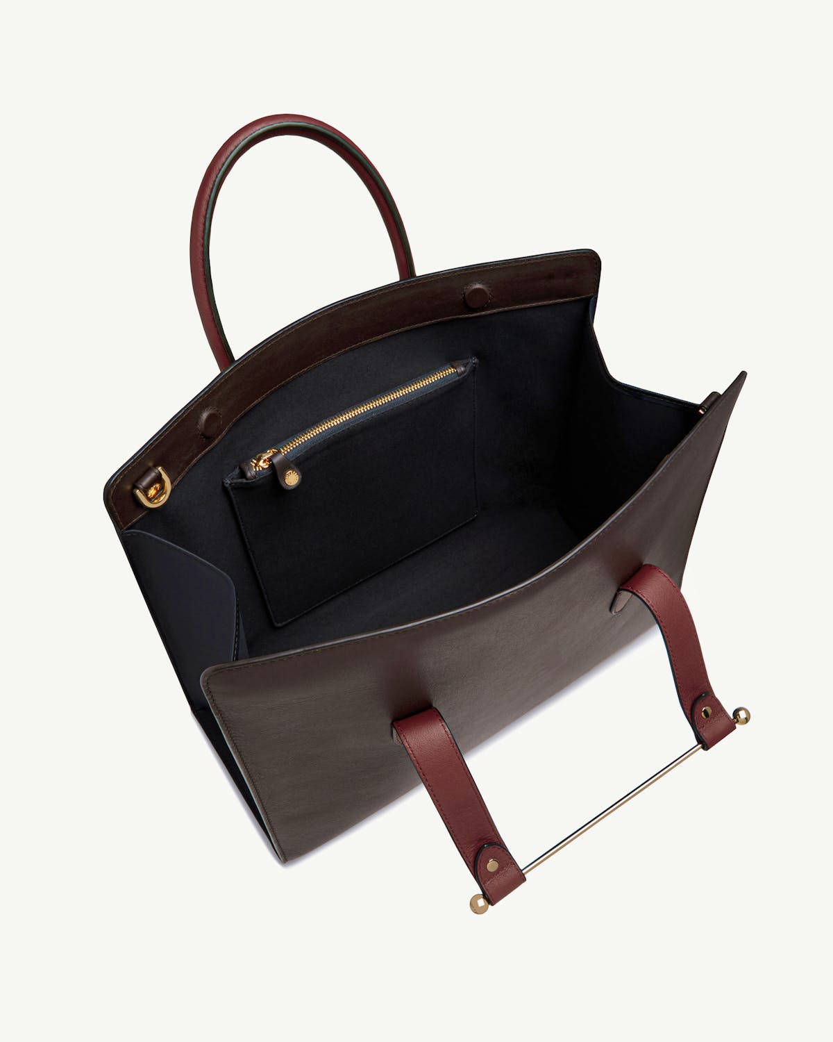 Open espresso, oxblood and black leather tote with interior zip pocket and gold bar.