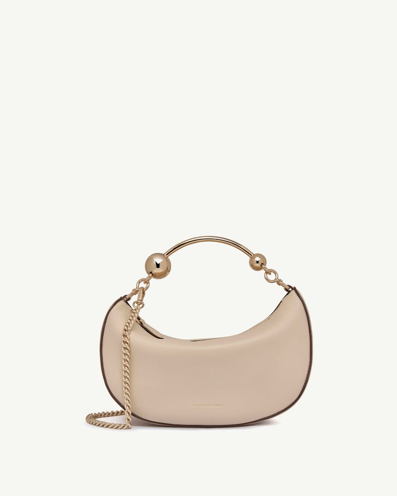 Oat crescent-shaped mini bag with gold ball handle and chain strap.