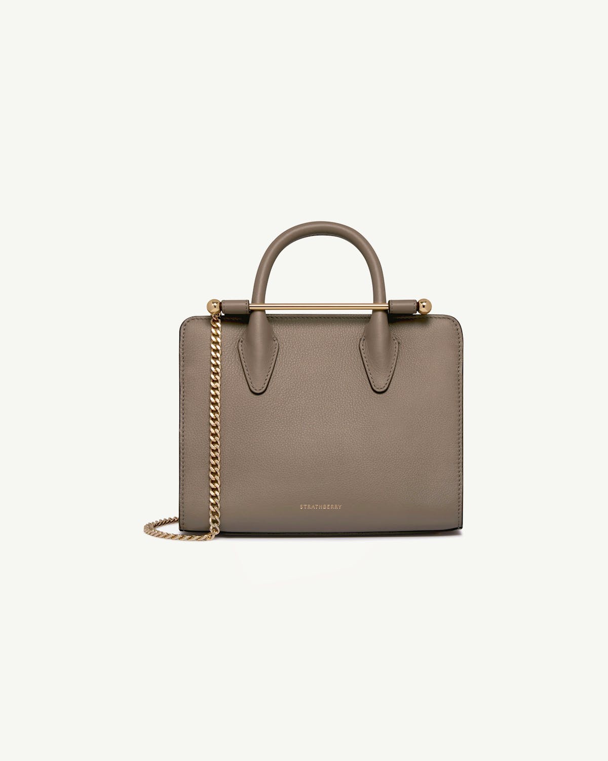 Taupe mini tote with top handles, gold bar and chain strap, Strathberry logo.