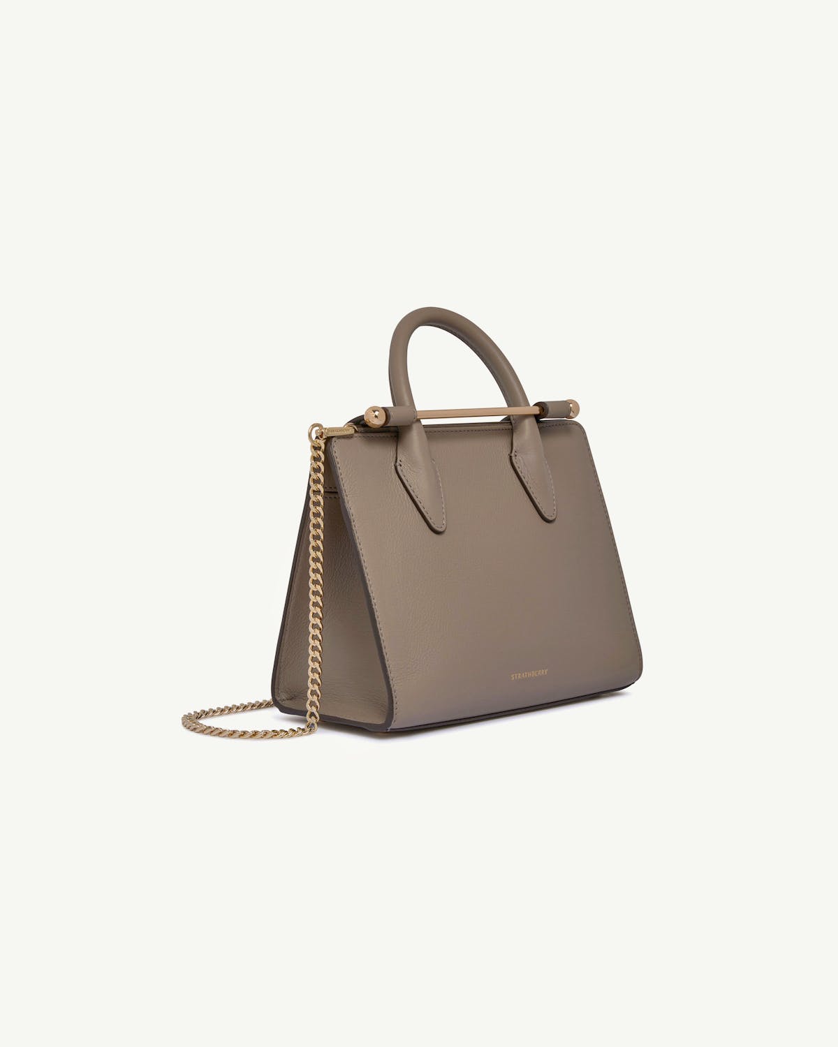 Taupe mini tote with top handle, gold bar detail and chain strap, Strathberry.