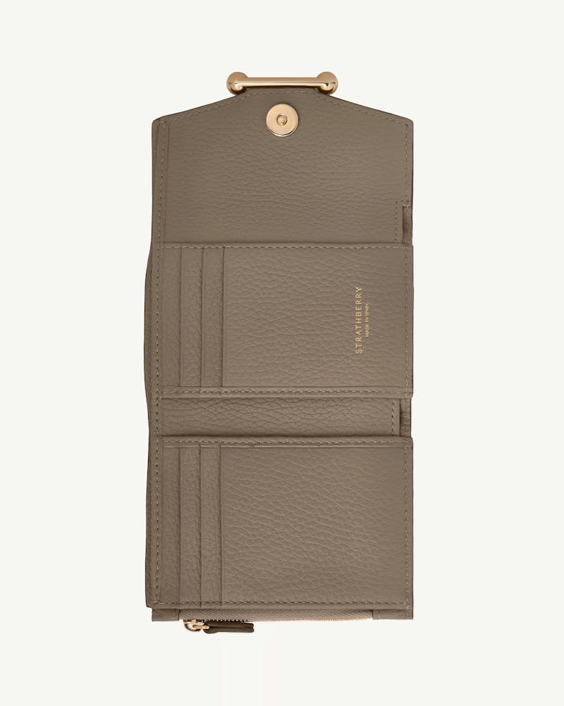 Taupe Strathberry trifold leather wallet, open showing card slots and gold clasp.