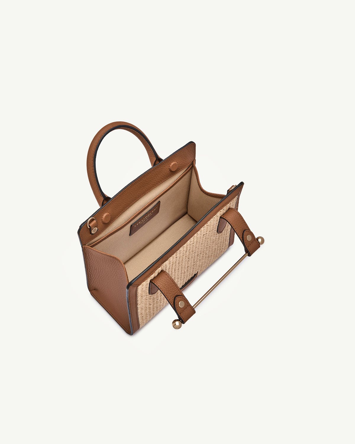 Tan leather-trimmed mini tote with natural raffia body and open interior.
