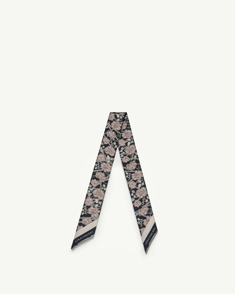 Black silk skinny scarf with oat-coloured floral print and Strathberry logo on tips.