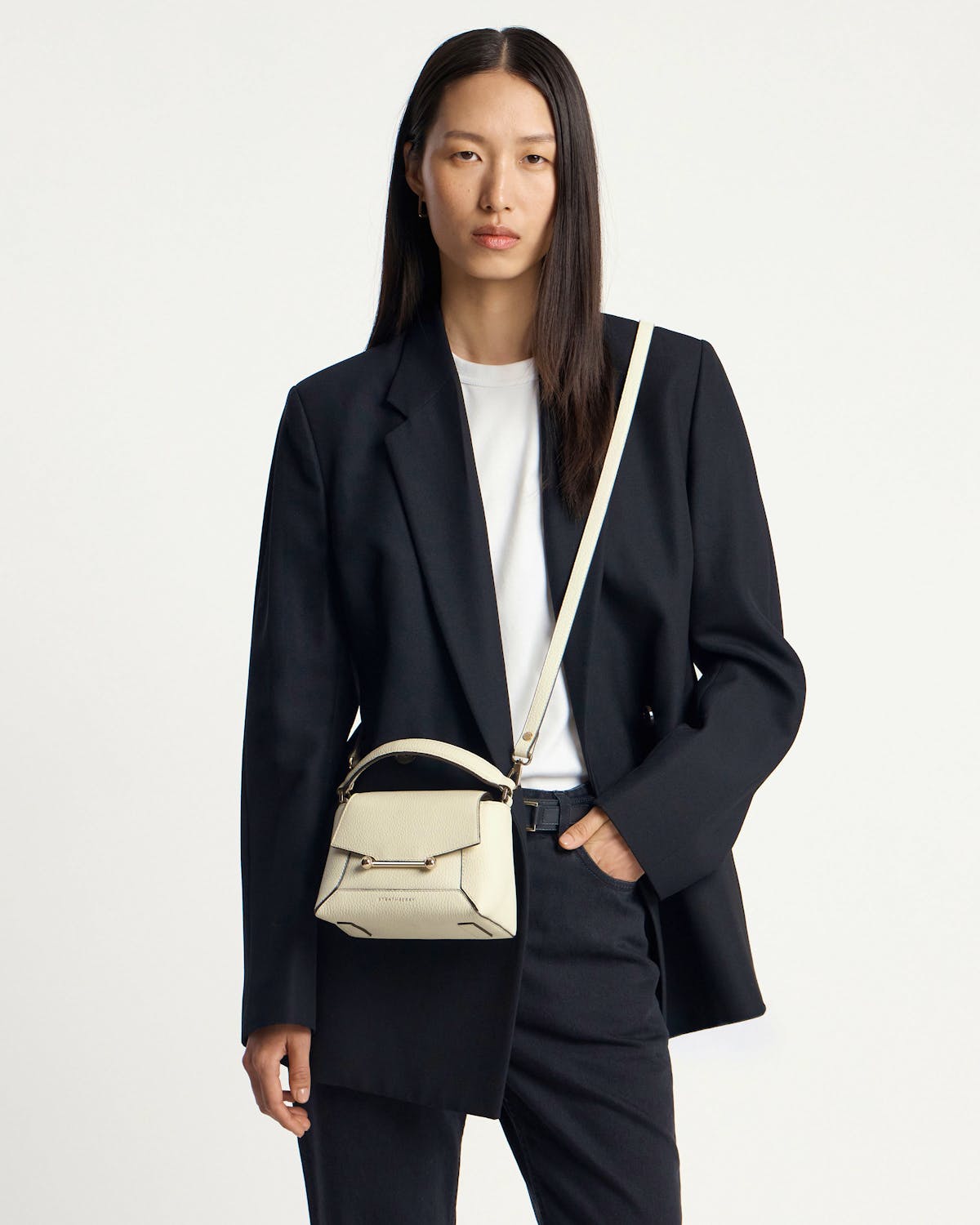 Model wearing black blazer and white t-shirt with vanilla Mosaic Nano crossbody bag.