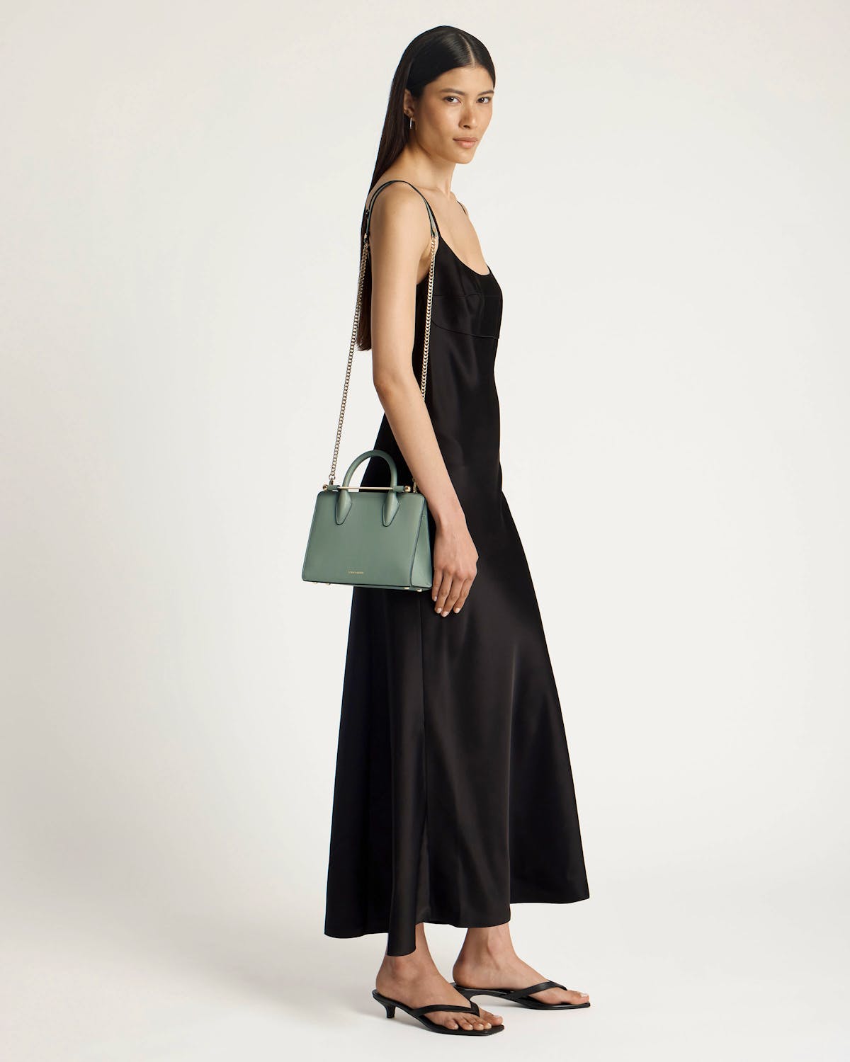 Model in black dress carrying a library green mini tote.