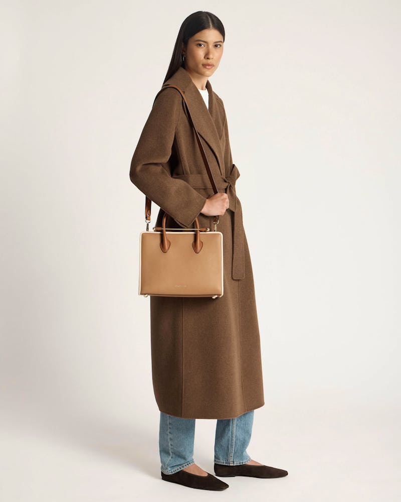 Model wearing brown coat holding caramel, chestnut and vanilla midi tote bag.