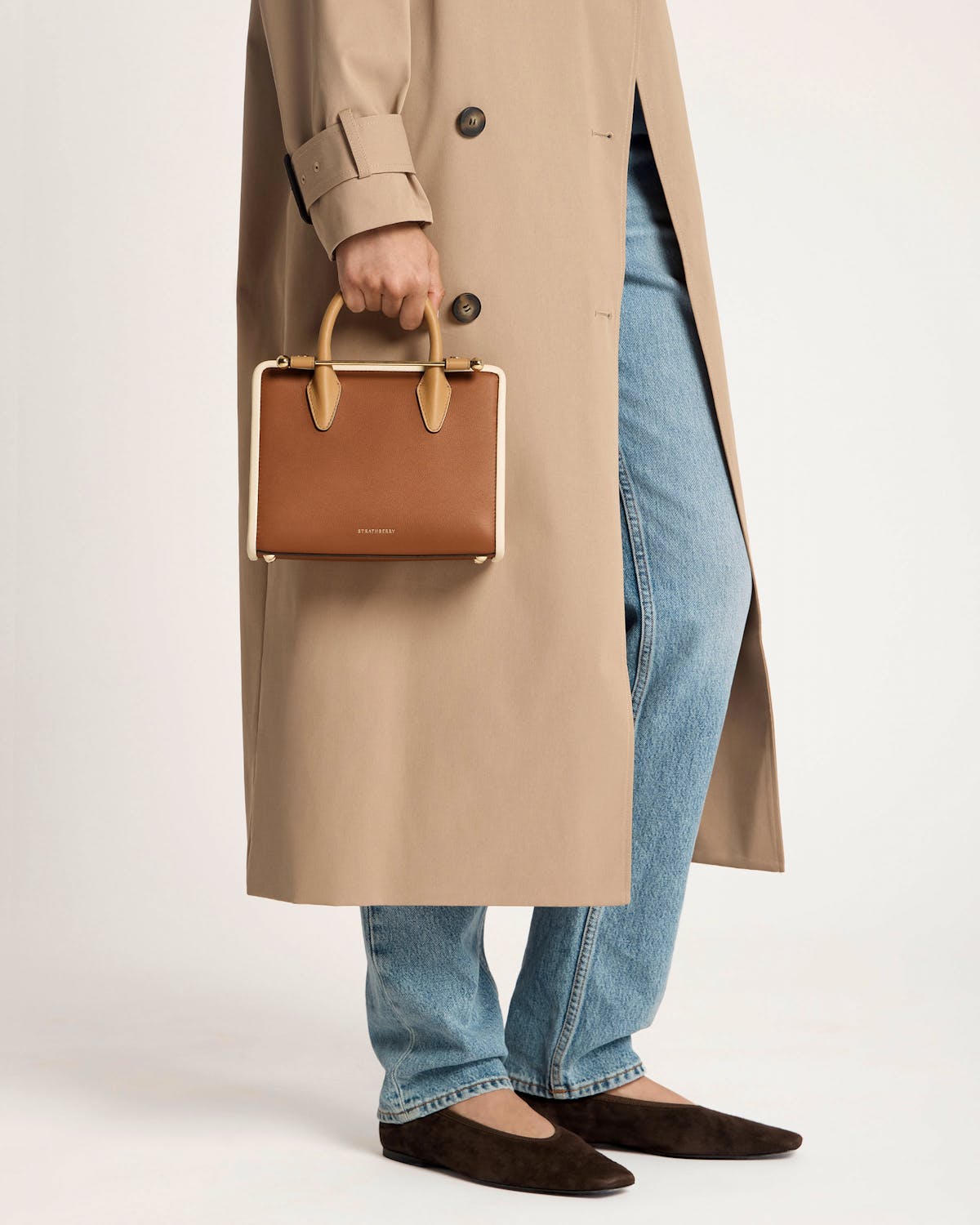 Hand holding Strathberry mini tote in caramel, sand and chestnut colours.