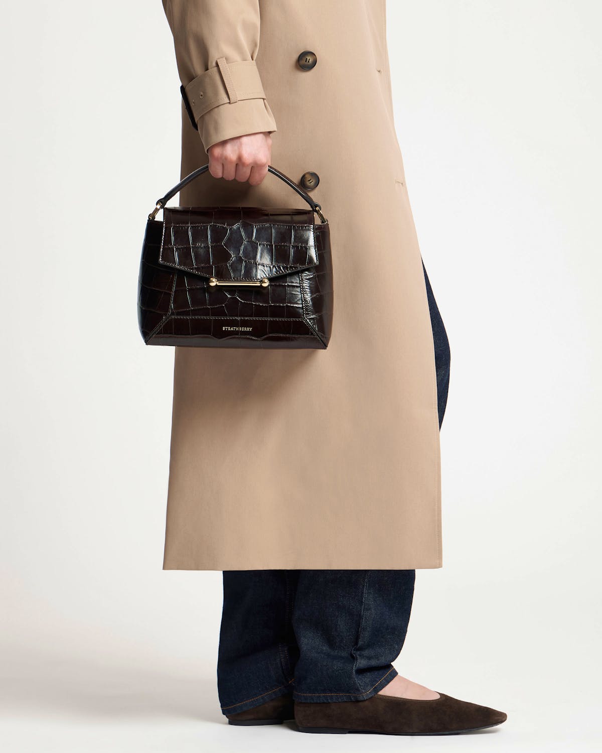 Hand-held Strathberry croc mosaic bag with top handle and gold bar fastening.