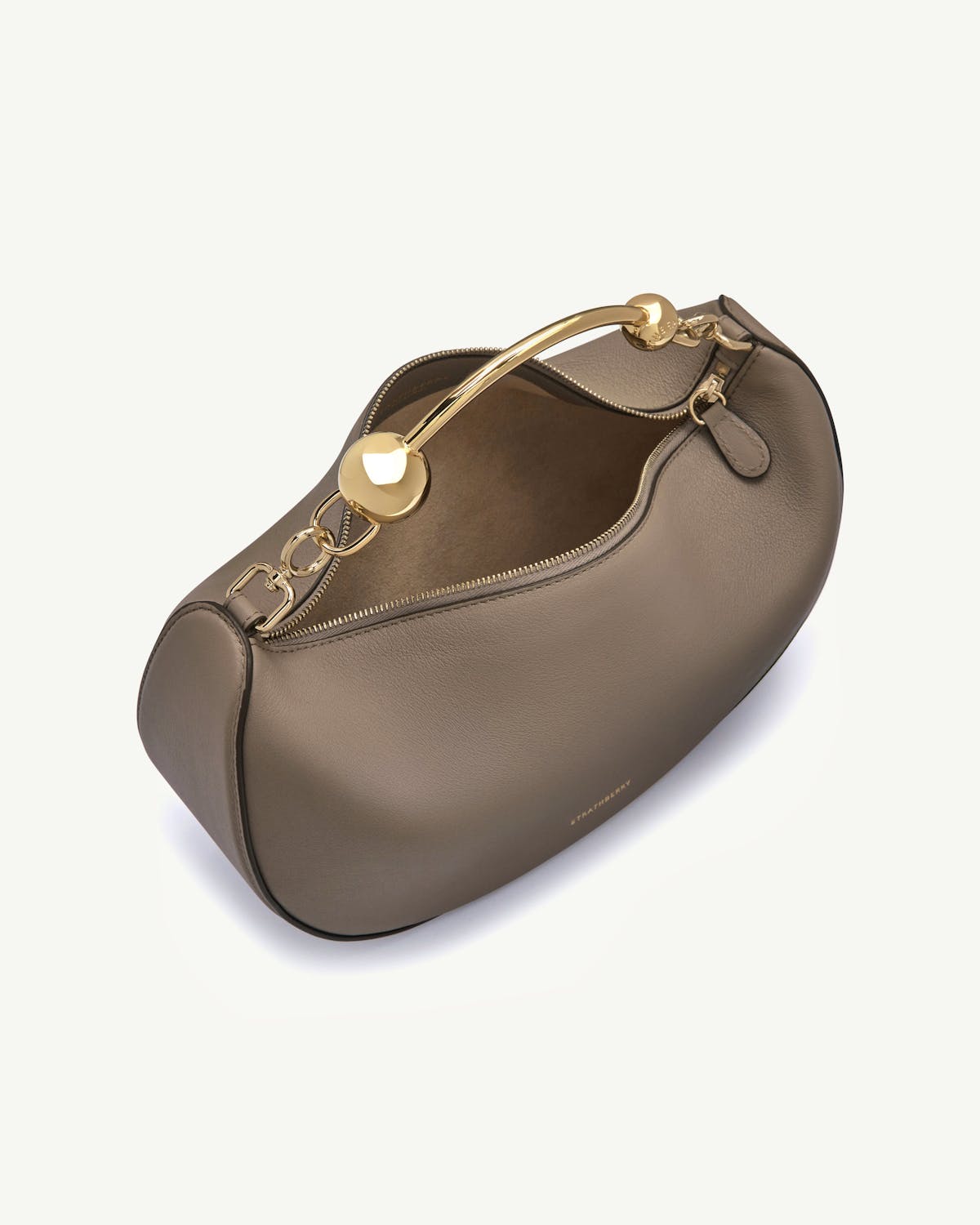 Taupe crescent moon bag with gold chain handle and visible Strathberry logo.