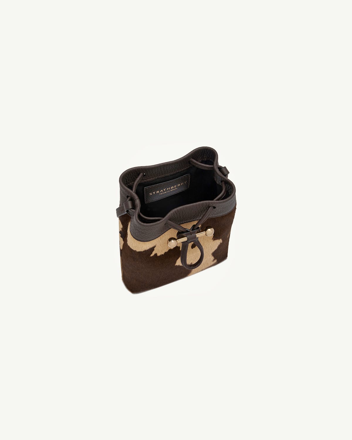 Top view of Strathberry Osette midi pouch in sand and espresso spot print.