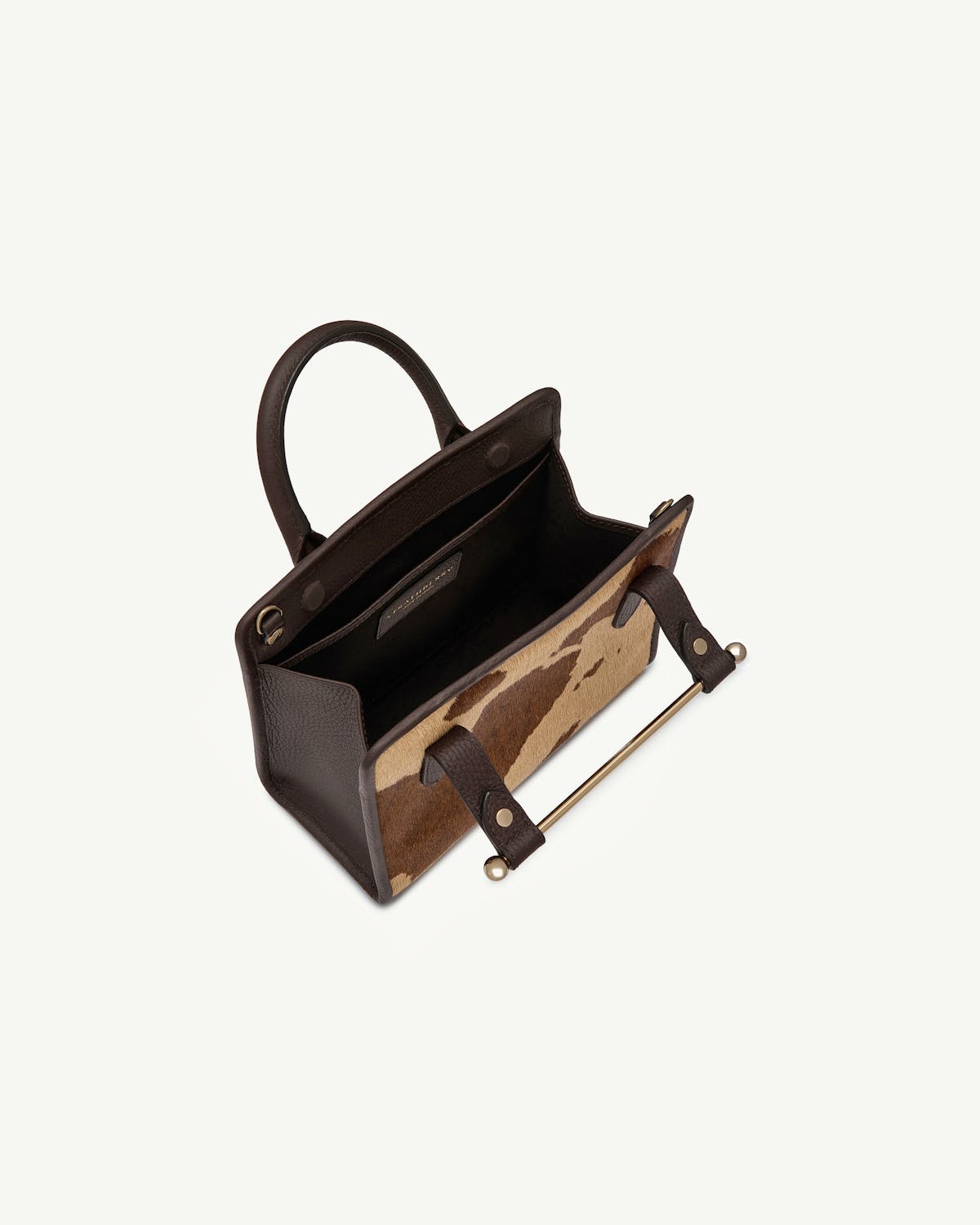 Mini tote with sand and espresso spot print, dark leather trim, open interior.
