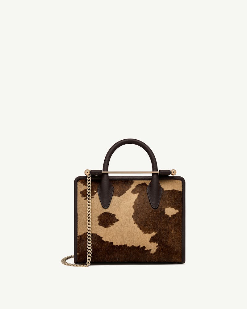 Mini tote with sand and espresso spot print, top handle, gold chain strap.