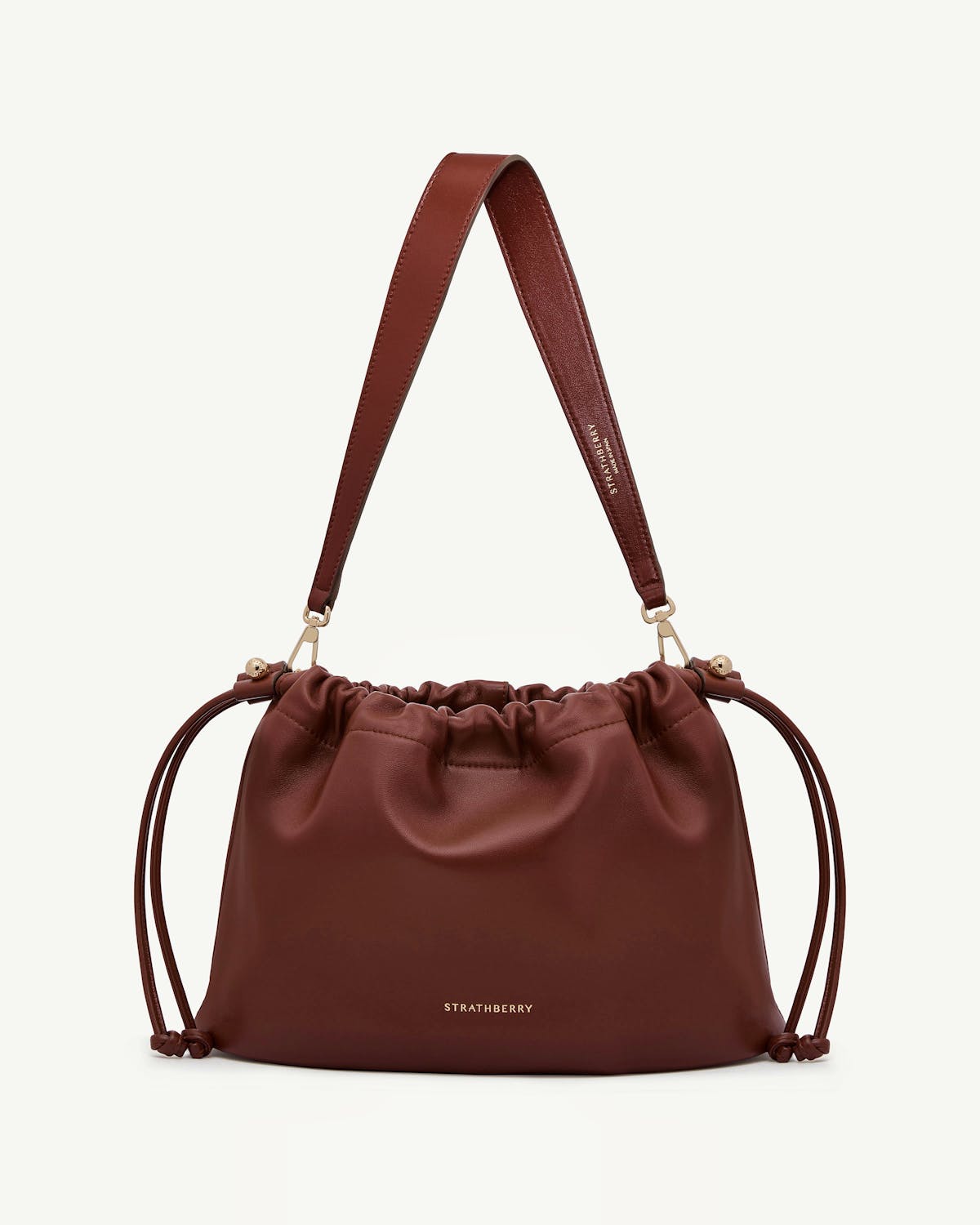 Strathberry Charlotte midi drawstring bag in walnut leather with shoulder strap.