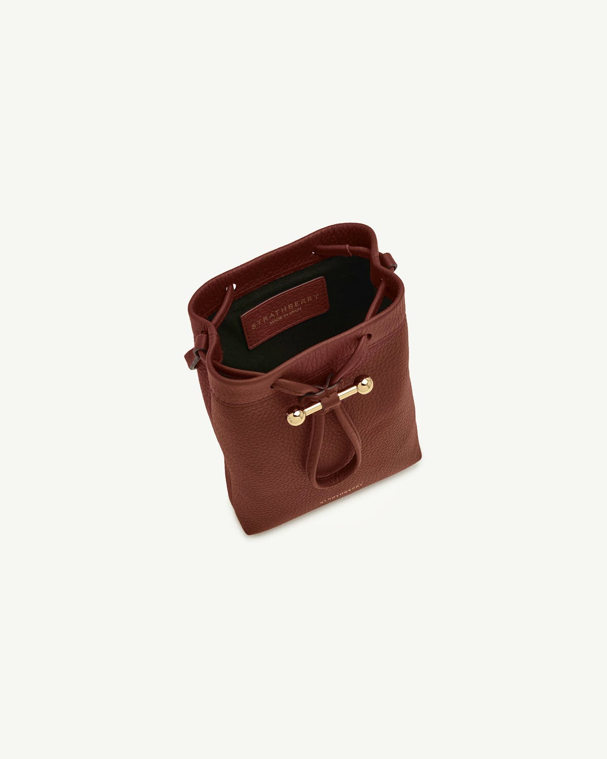 Walnut Strathberry Osette Midi pouch with drawstring top and gold bar detail.