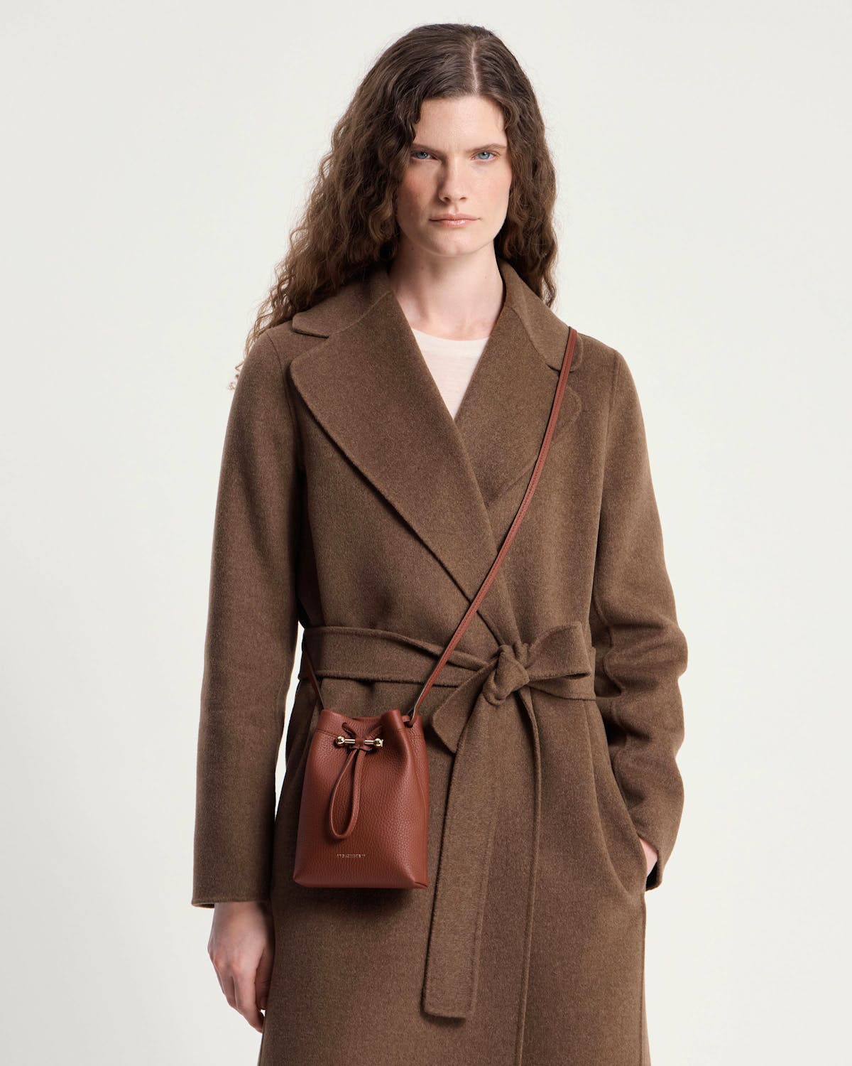 Model wearing brown coat with walnut Osette midi pouch crossbody bag.